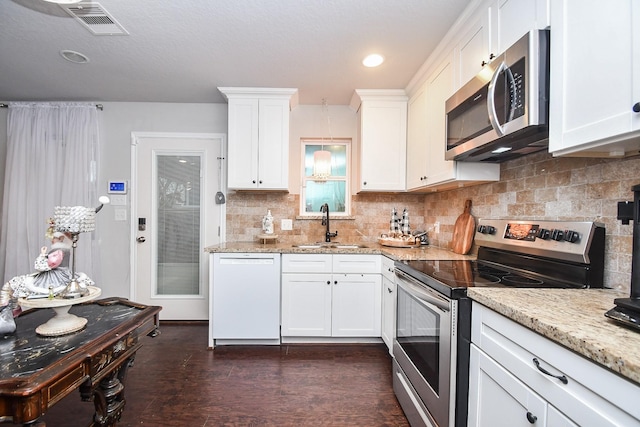 kitchen featuring decorative backsplash, sink, light stone countertops, appliances with stainless steel finishes, and white cabinets