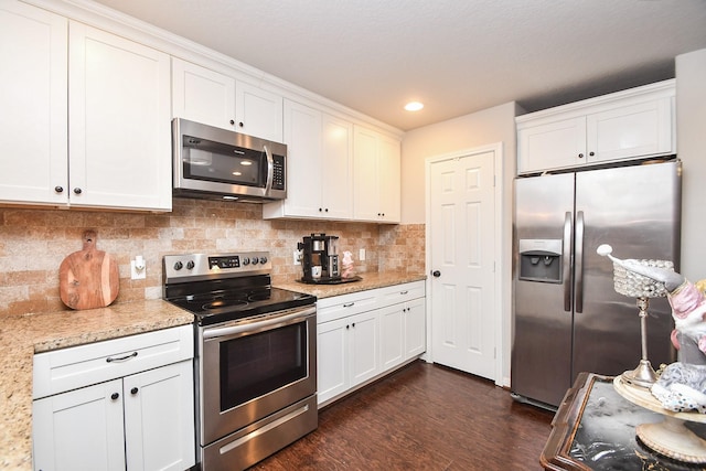 kitchen featuring light stone counters, white cabinetry, appliances with stainless steel finishes, and tasteful backsplash