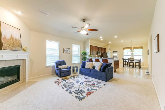 living room featuring ceiling fan, light colored carpet, and a fireplace