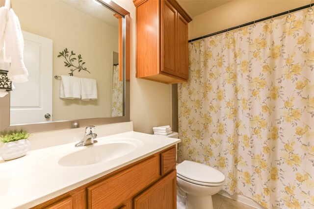 bathroom featuring curtained shower, tile patterned floors, toilet, and vanity