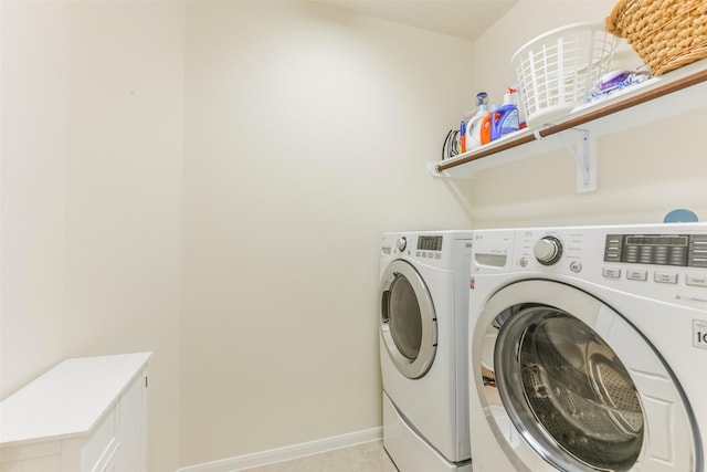 laundry area featuring light tile patterned floors and washing machine and clothes dryer