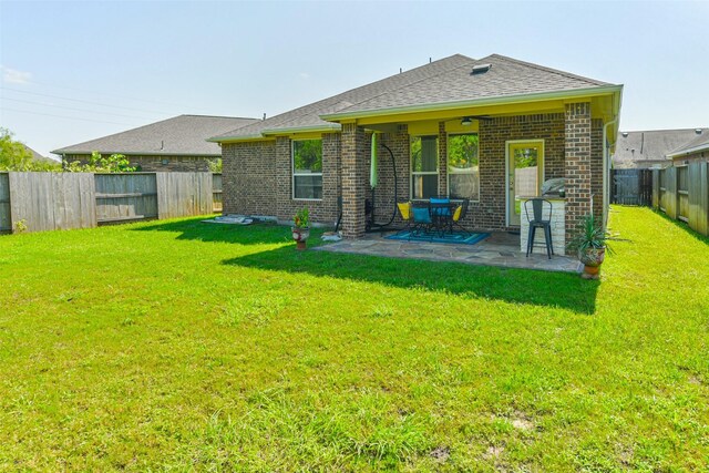 back of house featuring a lawn and a patio