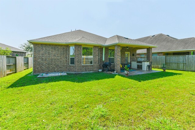 rear view of property featuring a yard and a patio