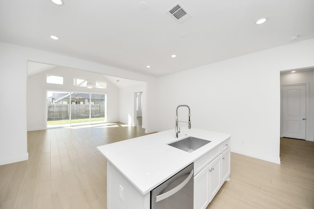 kitchen featuring white cabinetry, a kitchen island with sink, dishwasher, vaulted ceiling, and sink