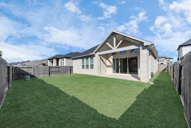 rear view of house featuring a lawn and a patio