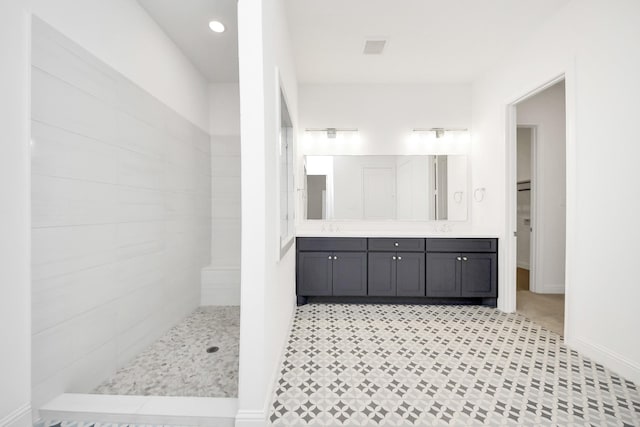 bathroom featuring walk in shower and vanity