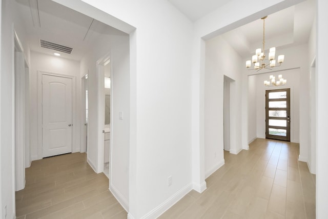 hall featuring an inviting chandelier