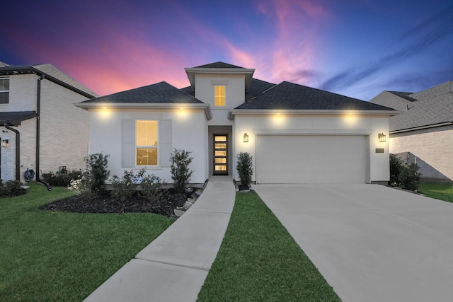 view of front of home featuring a garage and a lawn