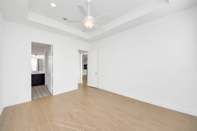 spare room with ceiling fan and a tray ceiling