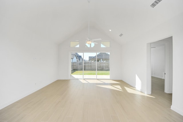 interior space with ceiling fan, a high ceiling, and light hardwood / wood-style flooring