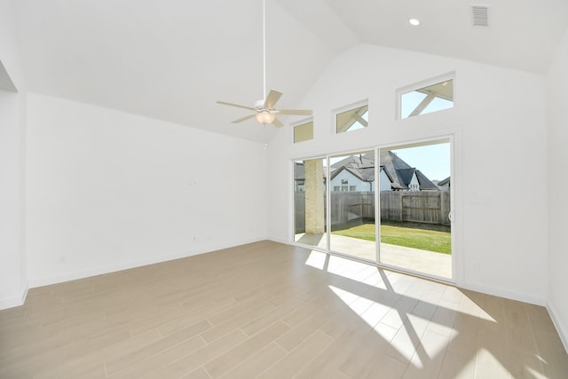 empty room with ceiling fan and high vaulted ceiling