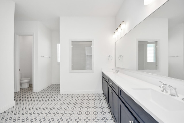 bathroom featuring toilet, vanity, and a shower