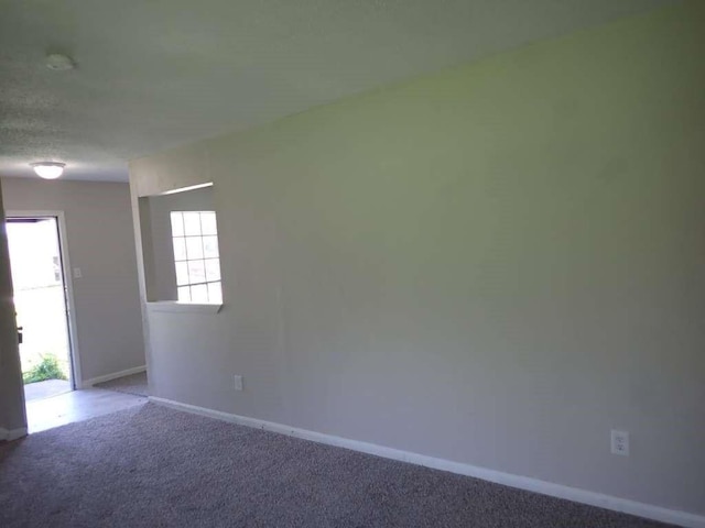 empty room featuring a textured ceiling and carpet flooring