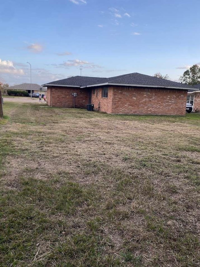 exterior space with cooling unit and a yard