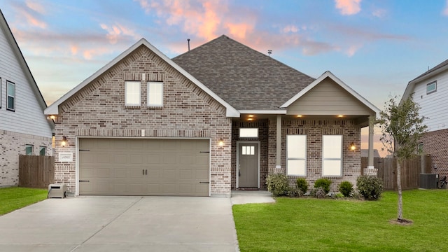 view of front facade with a garage, cooling unit, and a lawn