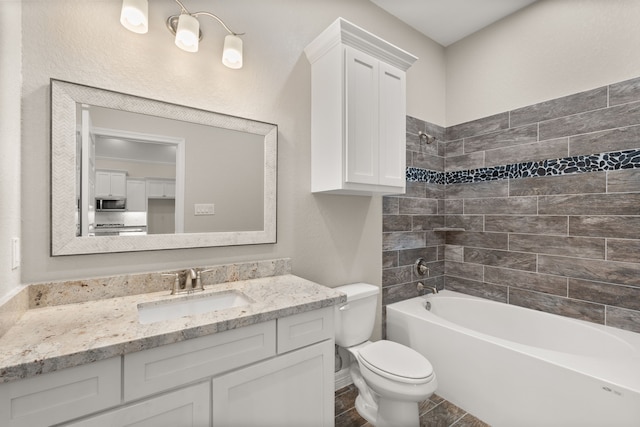 full bathroom with toilet, tiled shower / bath combo, and vanity