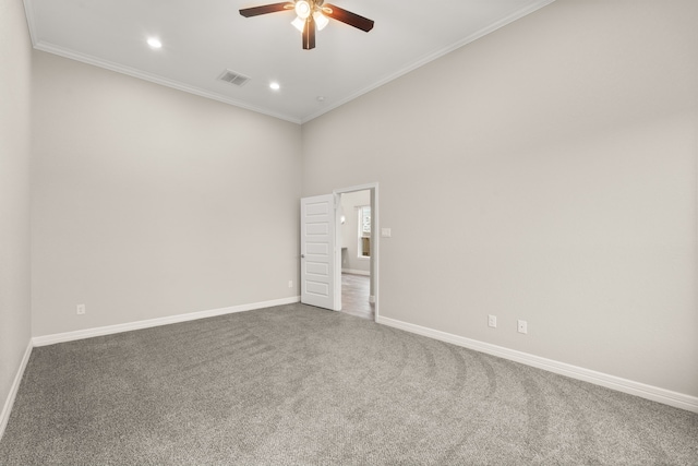 carpeted spare room featuring ceiling fan and crown molding