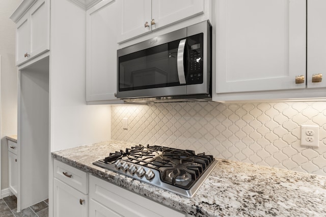 kitchen featuring backsplash, white cabinets, and stainless steel appliances