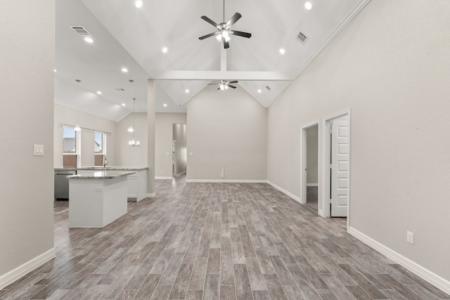 unfurnished living room featuring ceiling fan, light wood-type flooring, high vaulted ceiling, crown molding, and sink