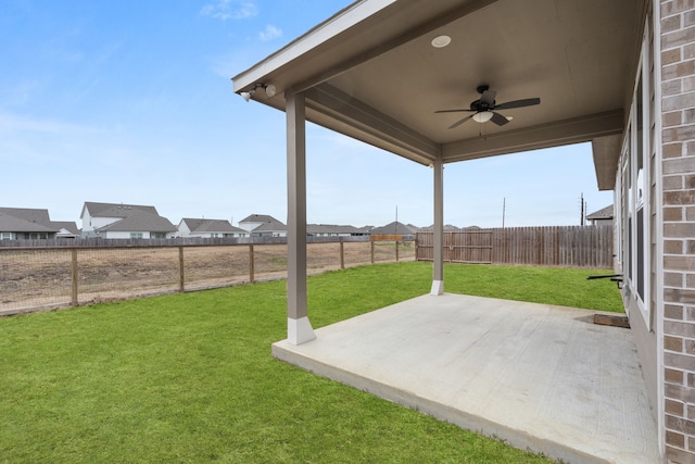 view of yard with ceiling fan and a patio