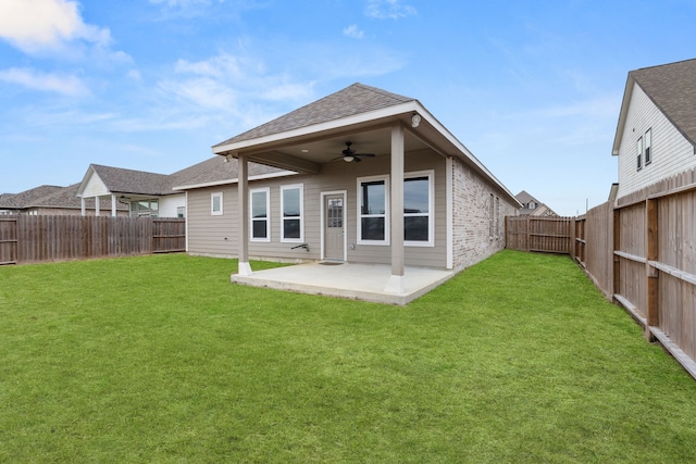 rear view of property with ceiling fan, a patio area, and a yard