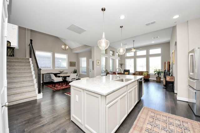 kitchen with a center island with sink, visible vents, appliances with stainless steel finishes, open floor plan, and a sink