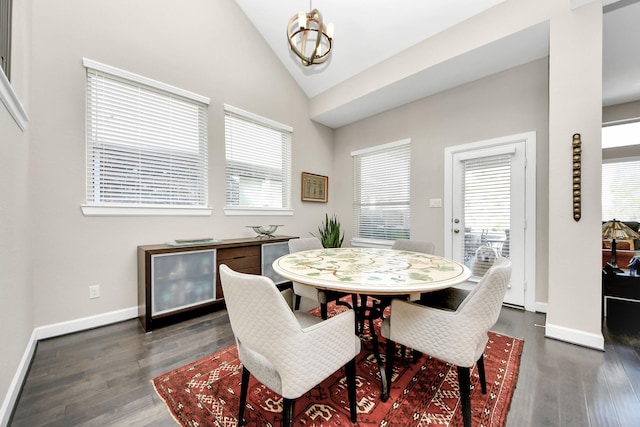 dining space featuring dark wood-style floors, vaulted ceiling, and baseboards