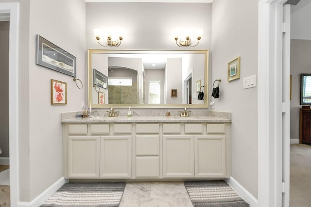 bathroom with double vanity, a sink, and tiled shower