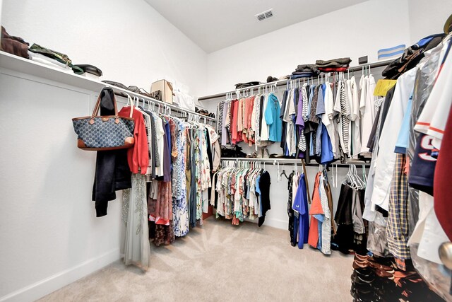 walk in closet with light colored carpet