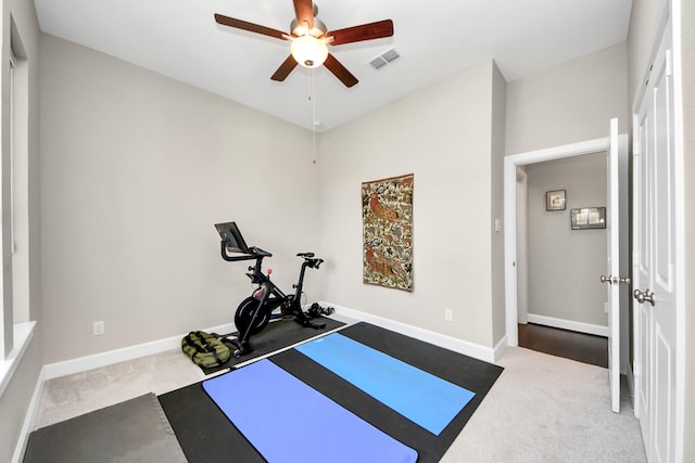 workout room with ceiling fan and light colored carpet