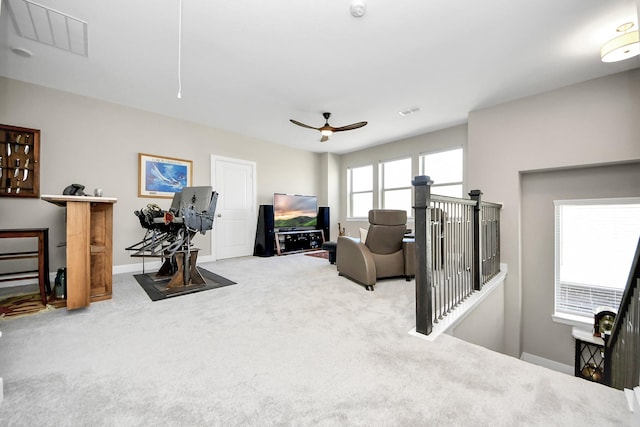 interior space with attic access, visible vents, baseboards, a ceiling fan, and carpet floors