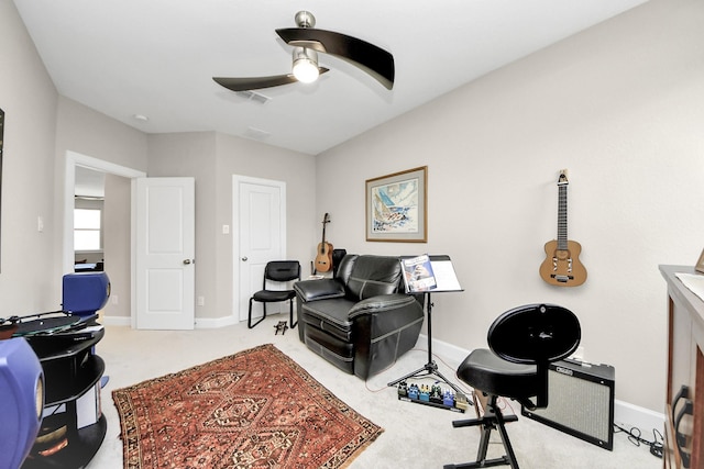 interior space with ceiling fan, visible vents, baseboards, and light colored carpet