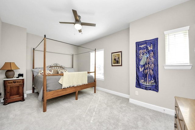 bedroom with ceiling fan, light carpet, and multiple windows