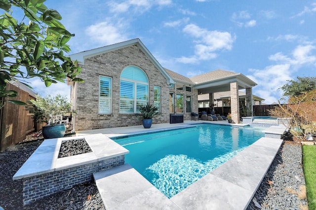 view of swimming pool featuring an in ground hot tub, an outdoor fire pit, a patio, and a fenced backyard