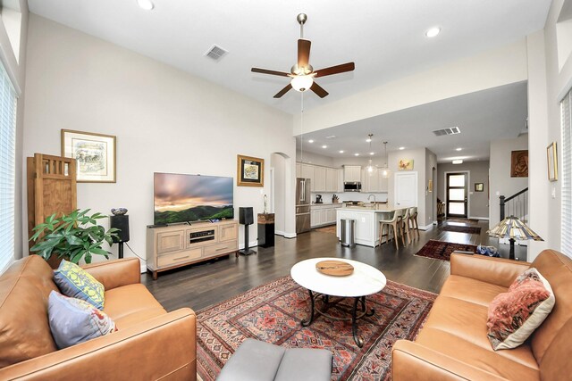 living room featuring ceiling fan and dark hardwood / wood-style flooring