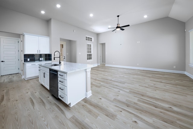 kitchen featuring black dishwasher, decorative backsplash, a kitchen island with sink, white cabinets, and sink