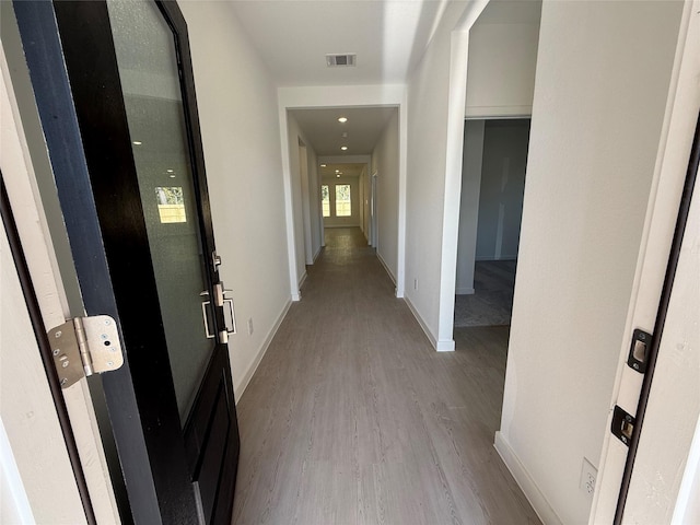 corridor with light hardwood / wood-style flooring