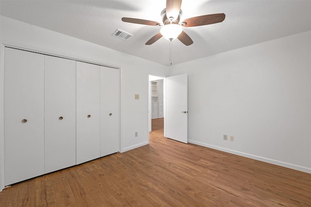 unfurnished bedroom featuring ceiling fan, a closet, and light hardwood / wood-style floors