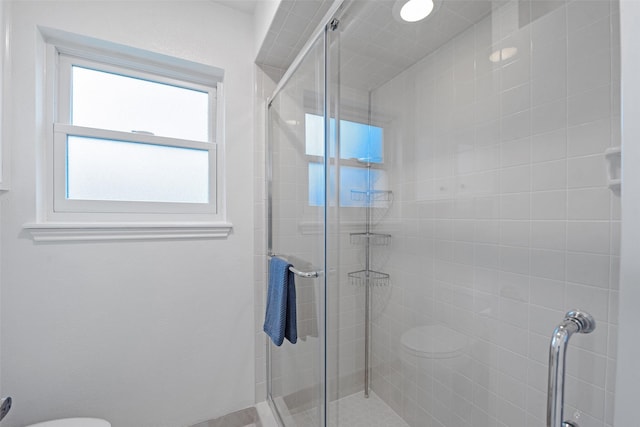 bathroom with toilet and an enclosed shower