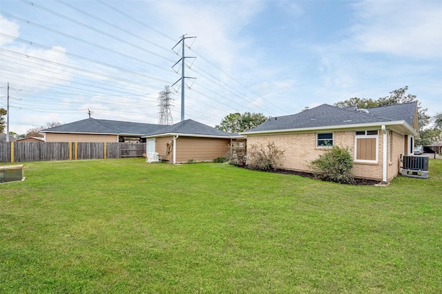 rear view of house with a lawn and central AC