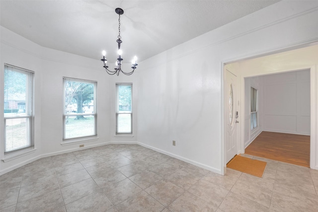 unfurnished room with light tile patterned flooring and an inviting chandelier