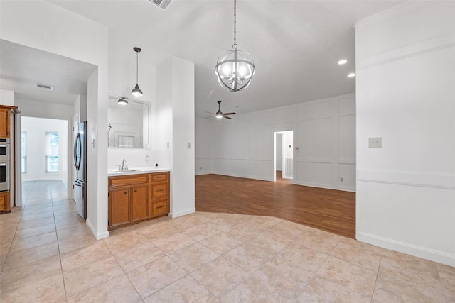 kitchen with sink, pendant lighting, light tile patterned floors, and stainless steel appliances