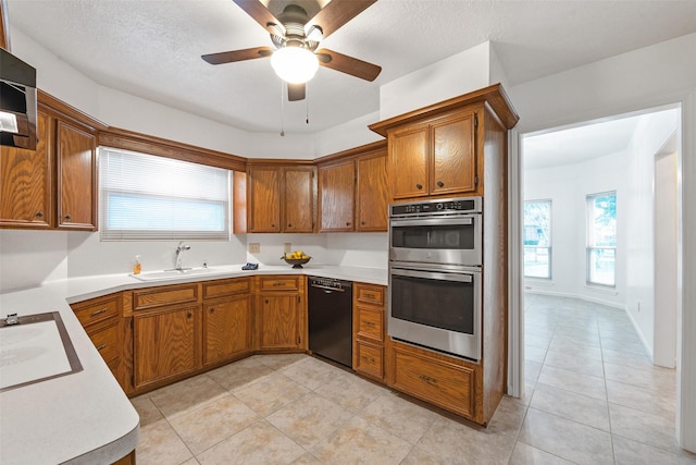 kitchen with ceiling fan, sink, black dishwasher, a textured ceiling, and double oven