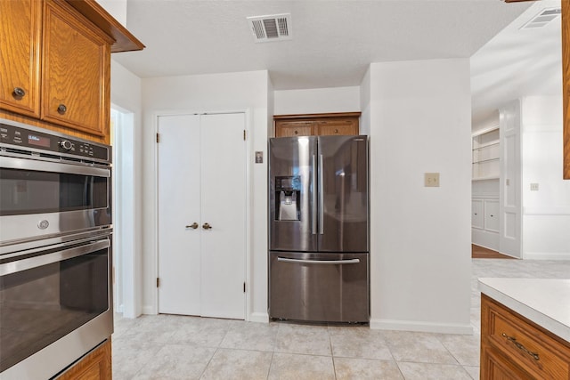 kitchen with light tile patterned floors and stainless steel appliances