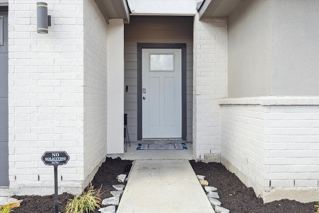 view of exterior entry with brick siding