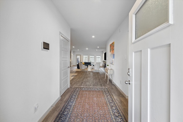 hallway with baseboards, wood finished floors, and recessed lighting