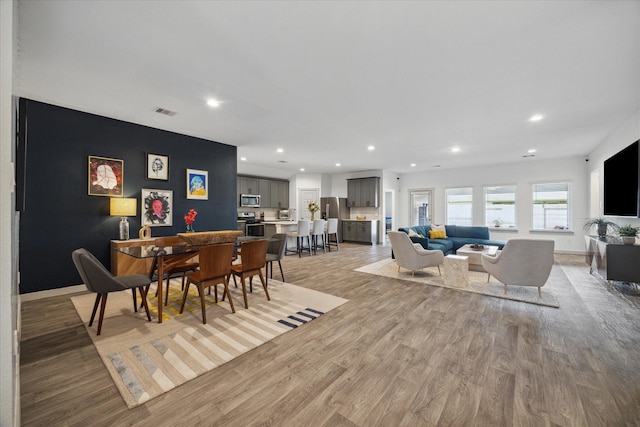 dining space featuring light wood-style floors, recessed lighting, and baseboards