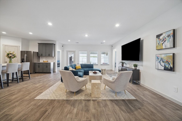 living room featuring baseboards, wood finished floors, and recessed lighting