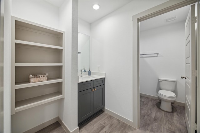 bathroom featuring vanity, wood finished floors, visible vents, and baseboards