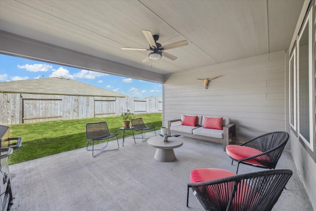 view of patio / terrace with an outdoor living space, fence, and a ceiling fan